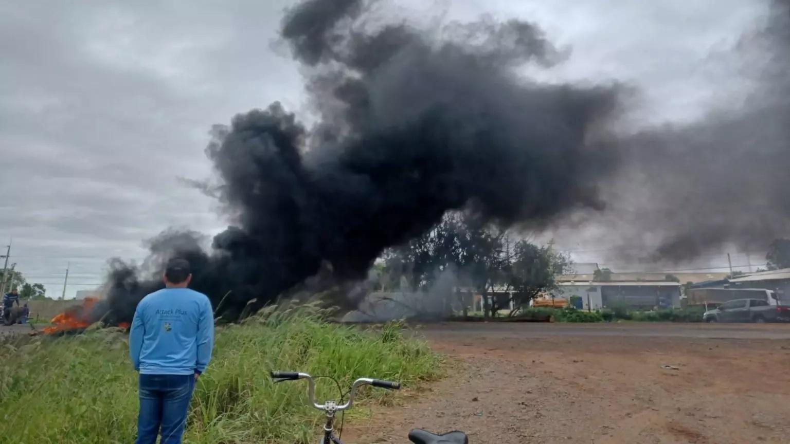 Trecho da BR-060 segue bloqueado e queima de pneus deixa área encoberta por fumaça preta